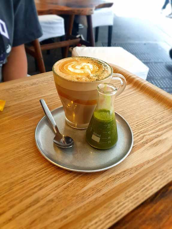 drink in a glass with matcha in a beaker